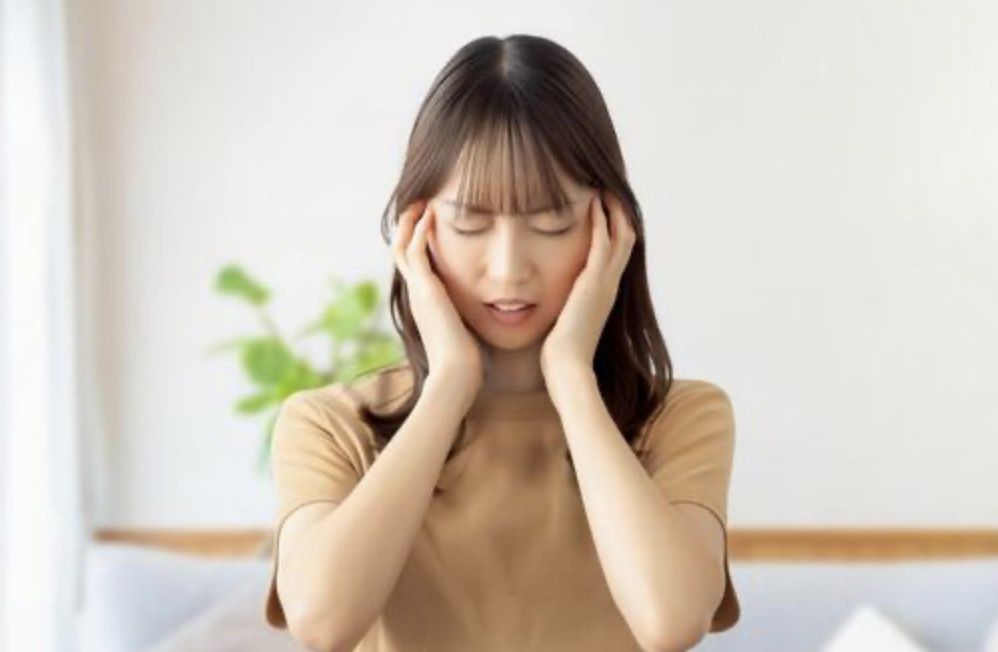 頭を押さえてつらそうにしている様子